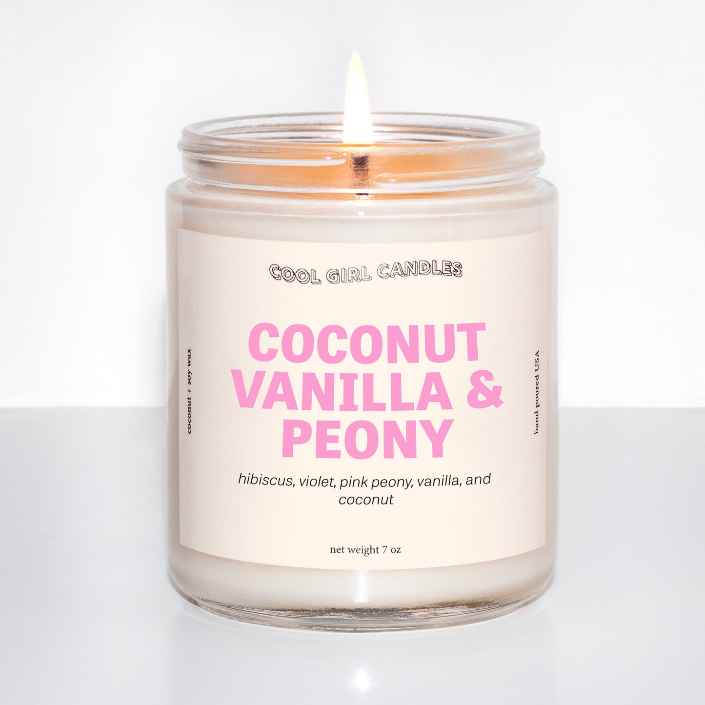 coconut vanilla and peony candle by cool girl candles is a fun, summer coconut candle featuring soft floral notes to round out this scent profile. It's giving an island getaway wearing flowers in your hair