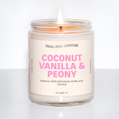 coconut vanilla and peony candle by cool girl candles is a fun, summer coconut candle featuring soft floral notes to round out this scent profile. It's giving an island getaway wearing flowers in your hair