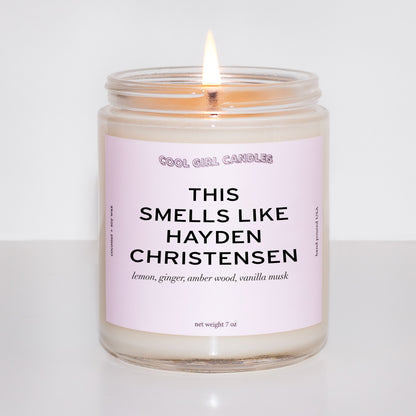 Candle in a glass jar with a pink label on a white background. The pink label says This Smells Like Hayden Christensen and is made by Cool Girl Candles