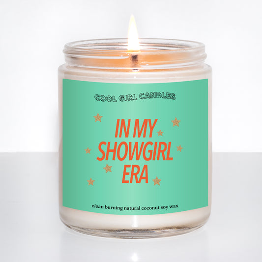 Candle in a jar with a green label reading 'In My Showgirl Era' on a white background that makes for the perfect swiftie gift, made by Cool Girl Candles
